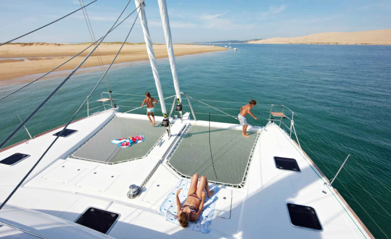 Sonnendeck eines Segel-Kreuzfahrtschiffes mit Blick auf einen Sandstrand